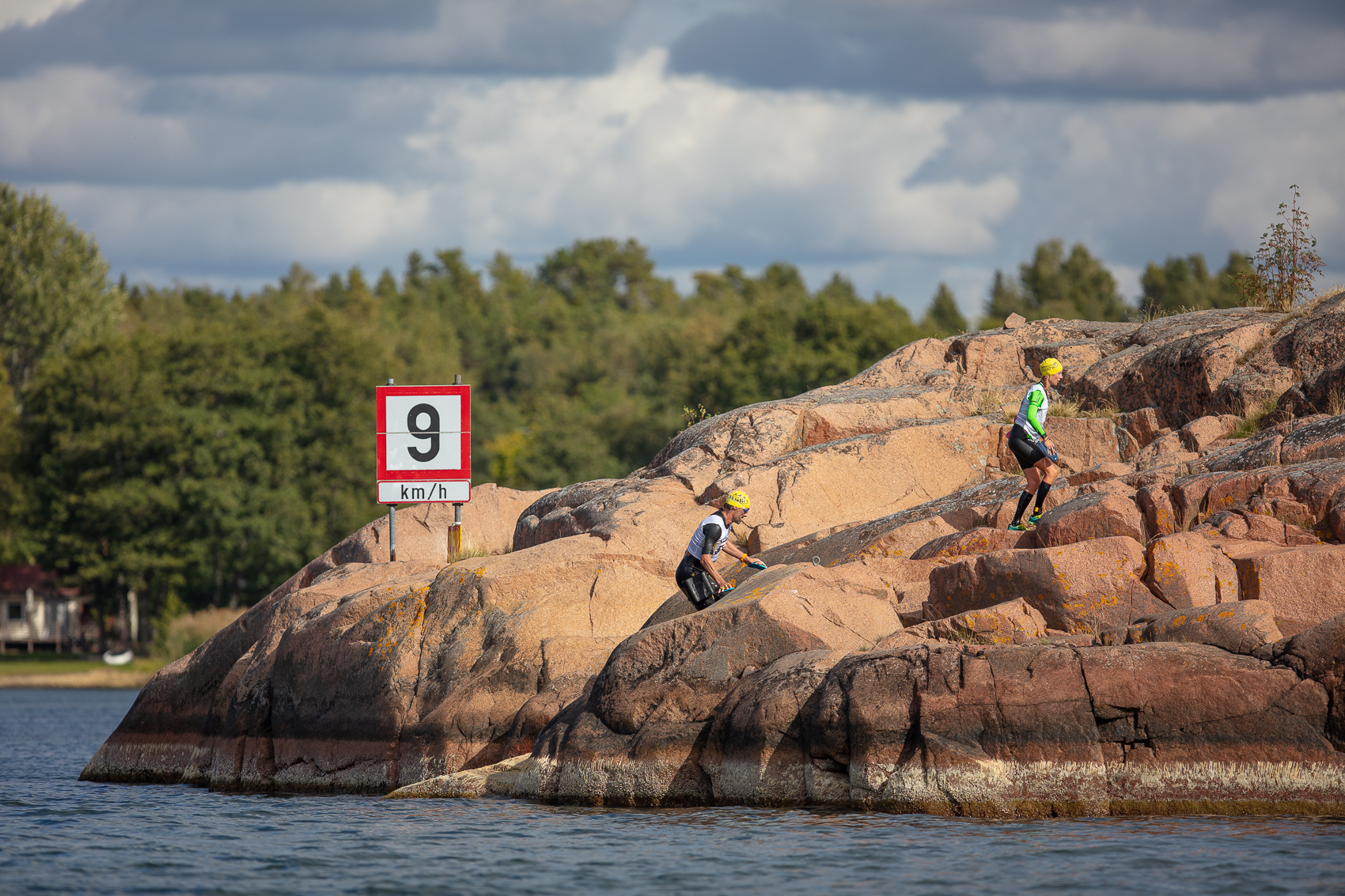 swimrun-deltagare på klippor vid vattnet